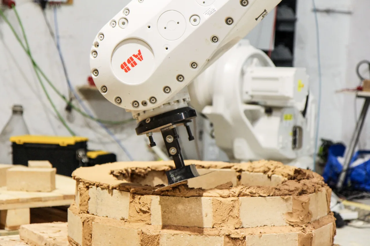 ABB robot assembling an earthen structure from blocks